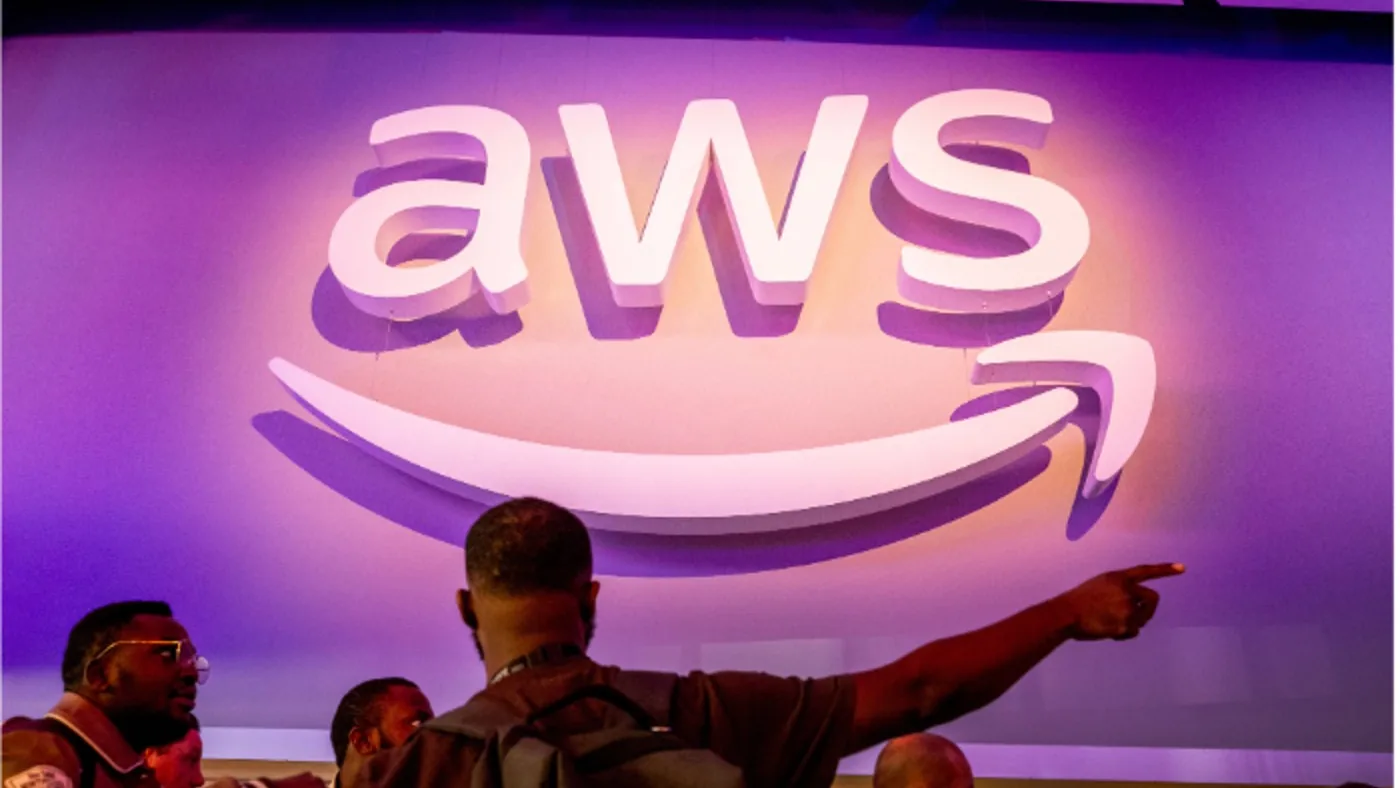 The AWS logo on a purple wall at an Amazon event