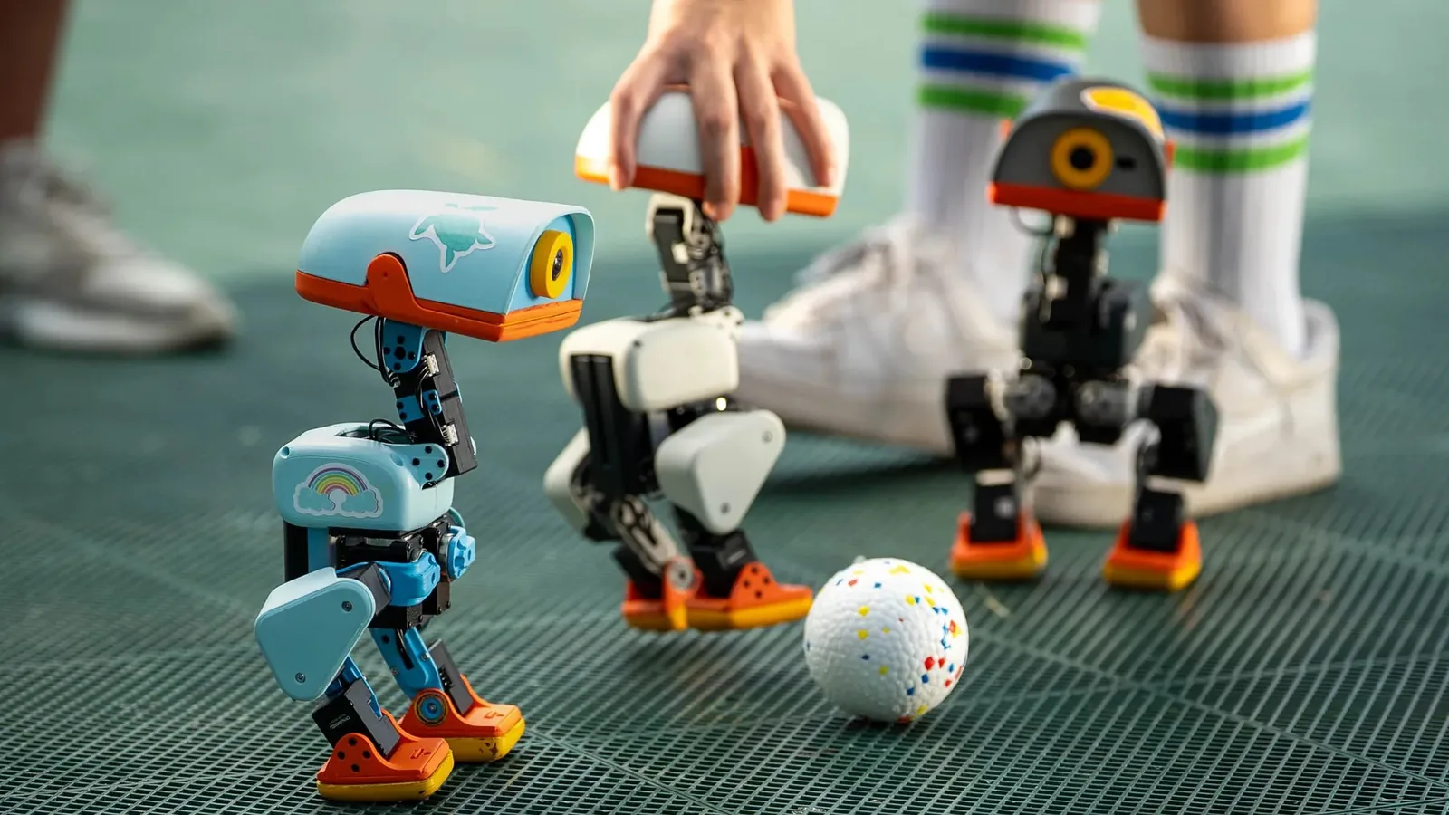 Microduck robots playing with a ball on a green court